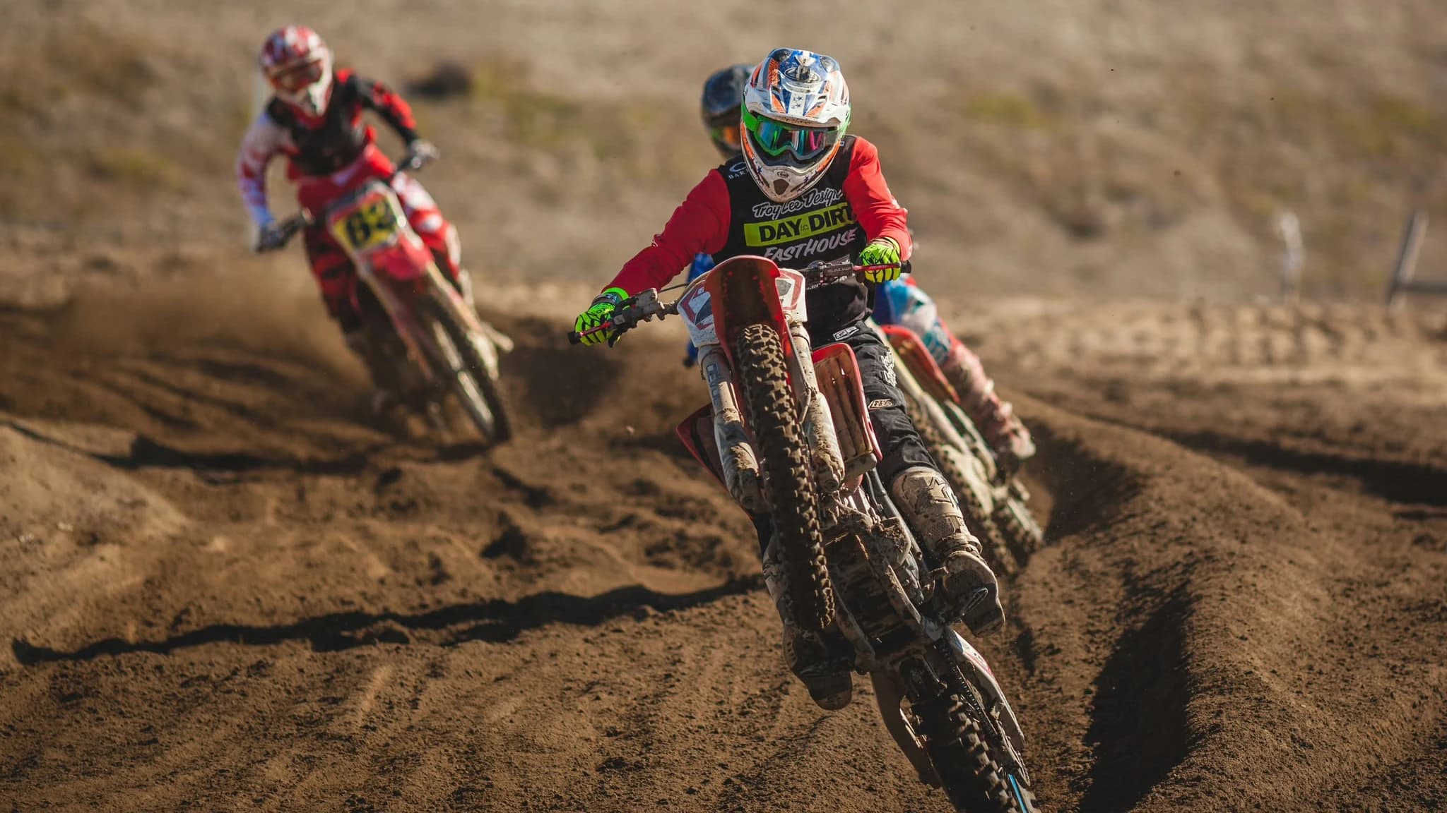 Riders racing toward the camera on a dirt track